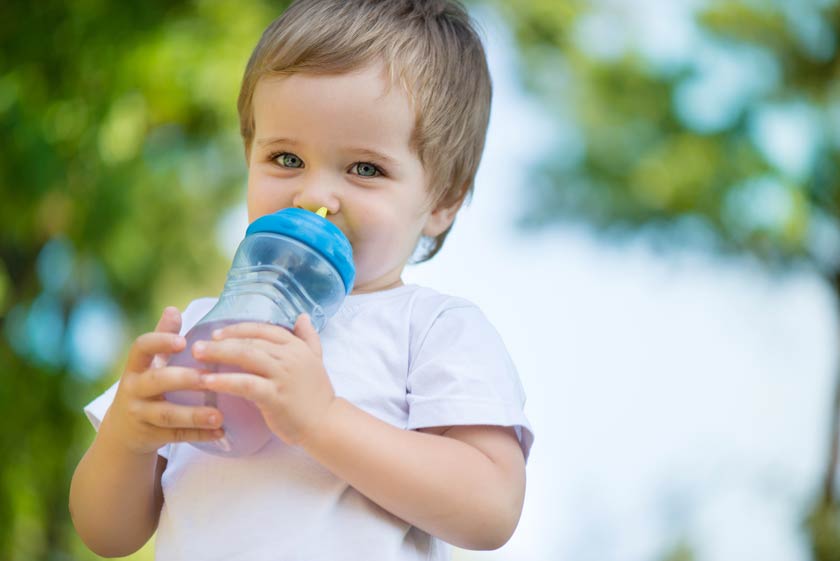 Kleines Kind in der Natur mit Trinkflasche für Kleinkinder