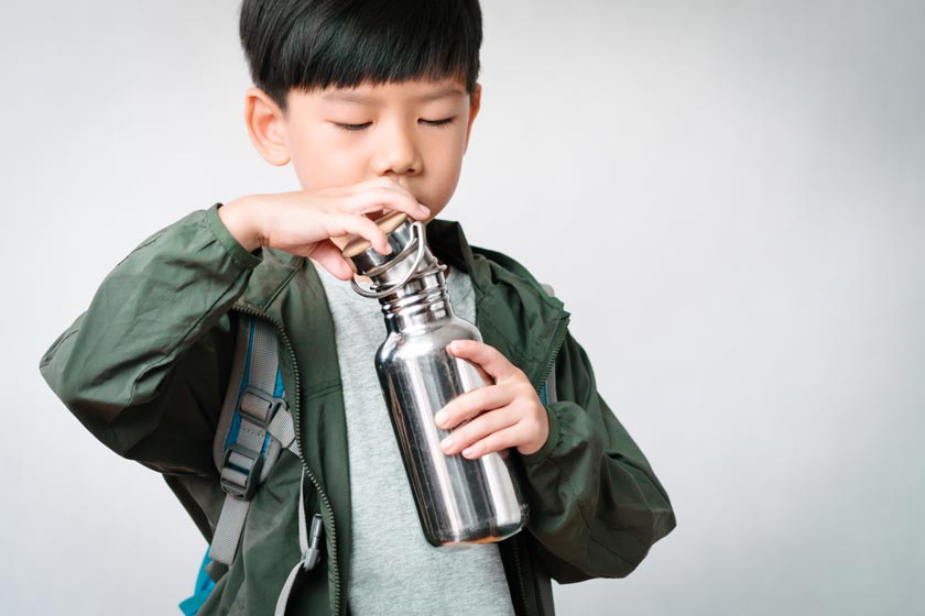 Junge hält Edelstahl Trinkflasche für Kinder