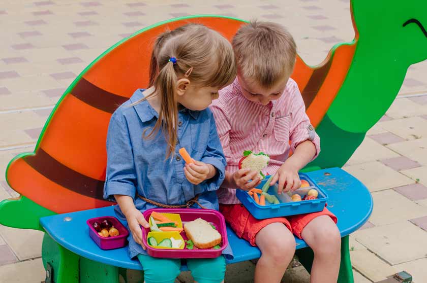 Zwei Kinder mit Brotdose im Kindergarten