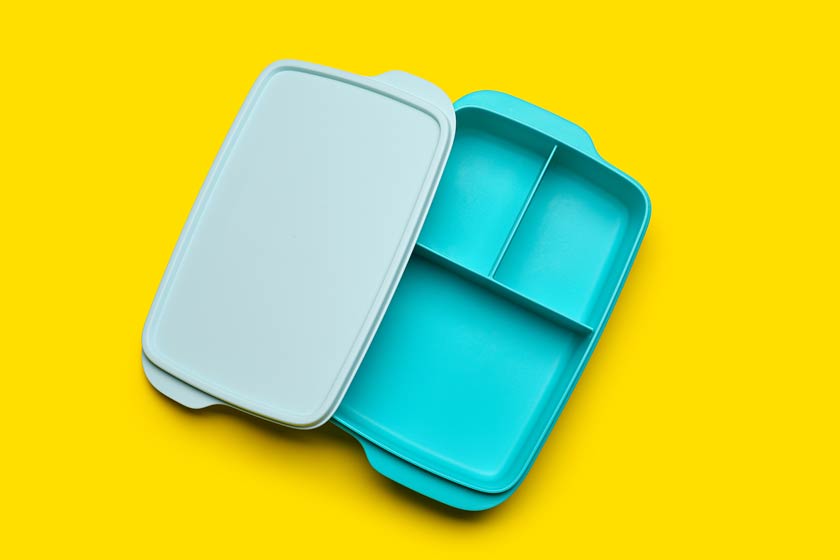 Blaue Brotdose mit Fächern auf gelbem Grund